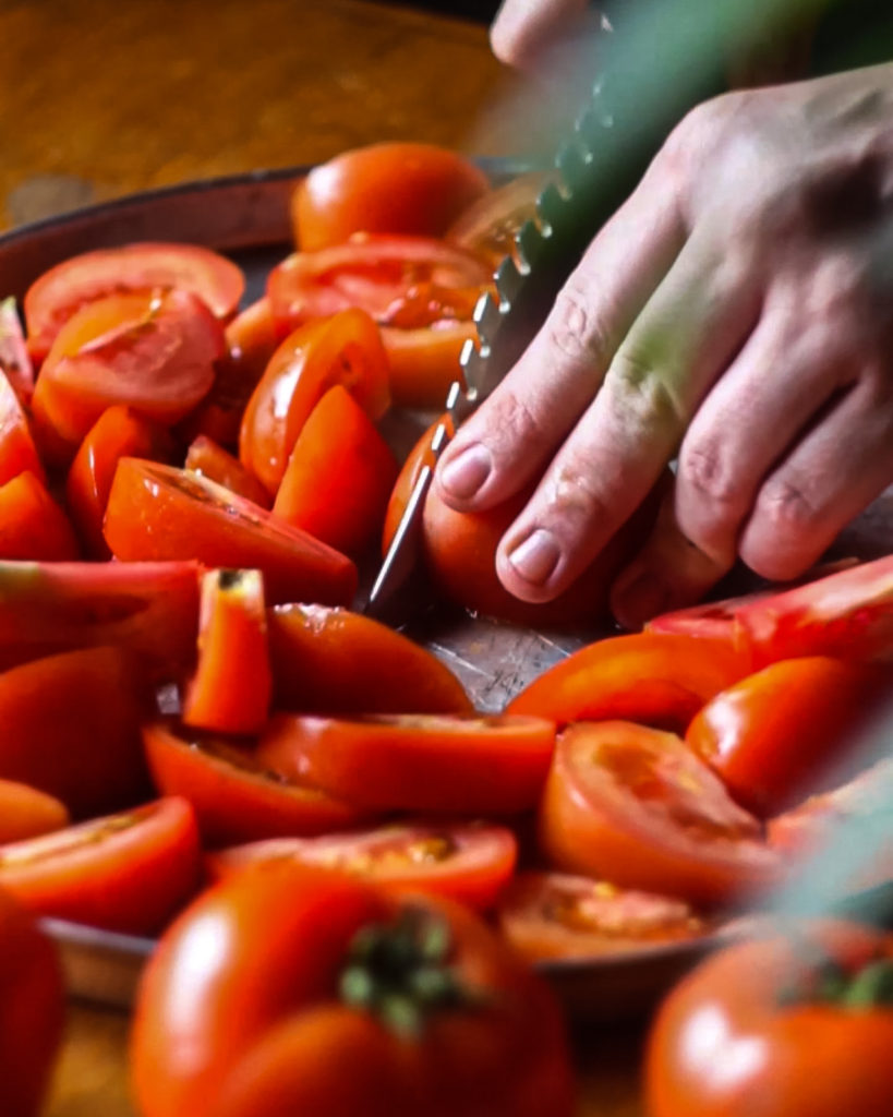 Cortando tomates para o preparo de um molho de tomate caseiro